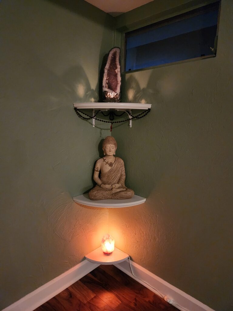 A candle and some shelves with a statue on them