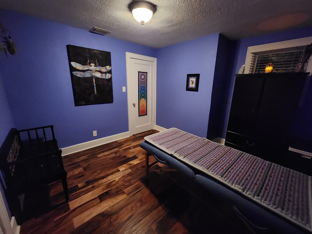 A bedroom with blue walls and wooden floors.